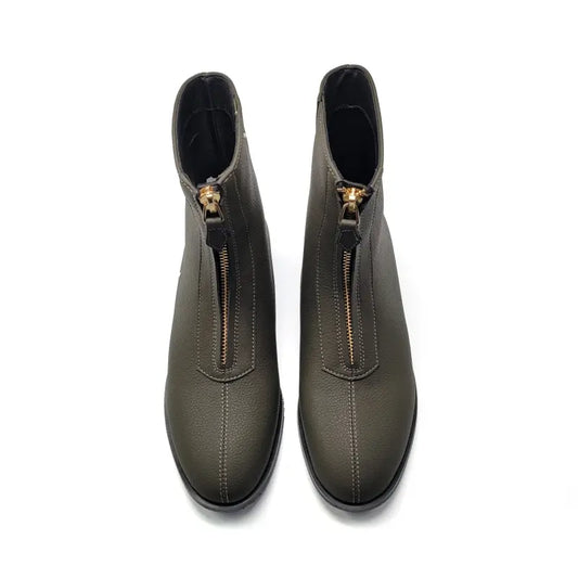 Pair of green ankle boots with gold zippers on a white background