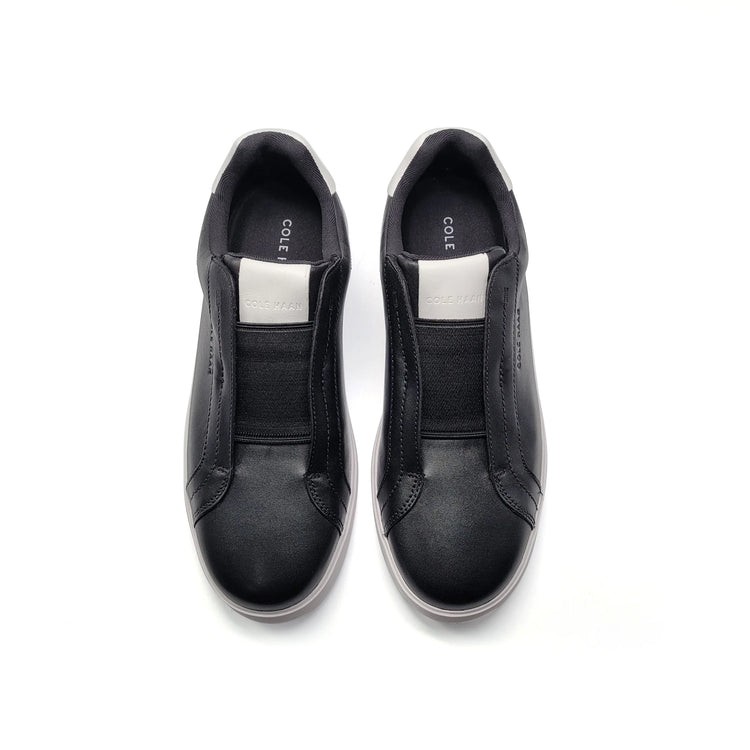 Black slip-on shoes with 'Cole' branding on a white background