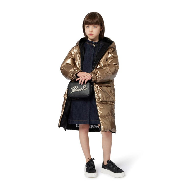 Person wearing a long metallic gold coat on a white background