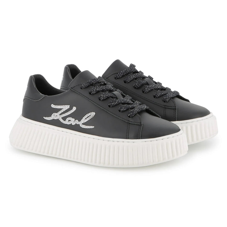 Black sneakers with white sole on a white background
