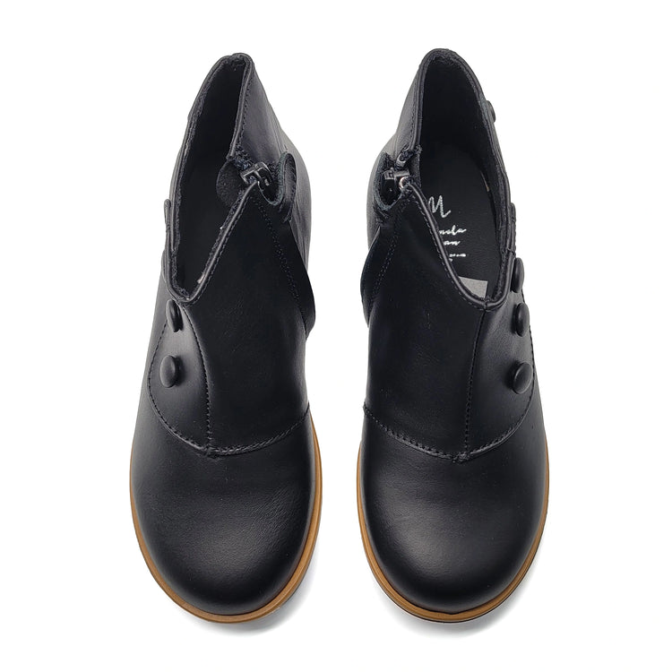 Pair of black leather shoes with brown soles on a white background