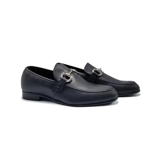 Pair of navy blue loafers with silver buckles on a white background