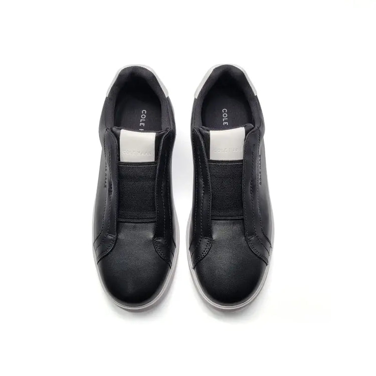 Black slip-on shoes with 'Cole' branding on a white background