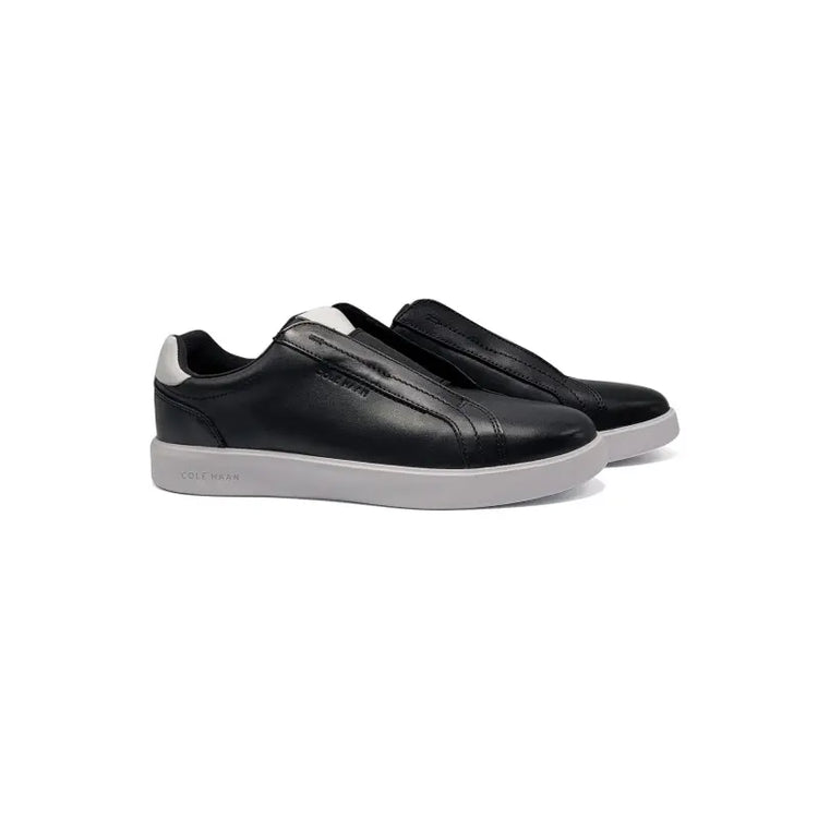 Black slip-on sneakers with white soles on a white background
