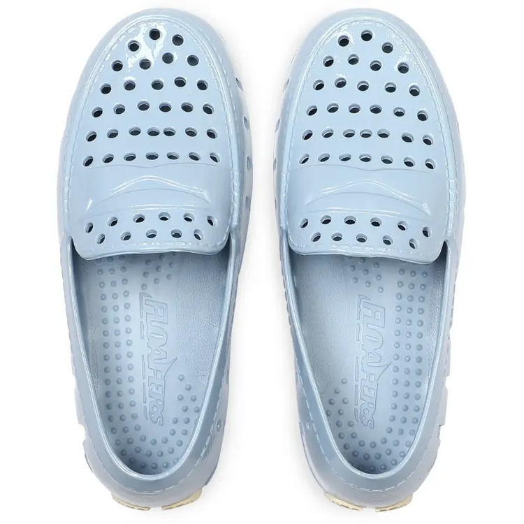 Pair of light blue slip-on shoes with a brand logo on a white background