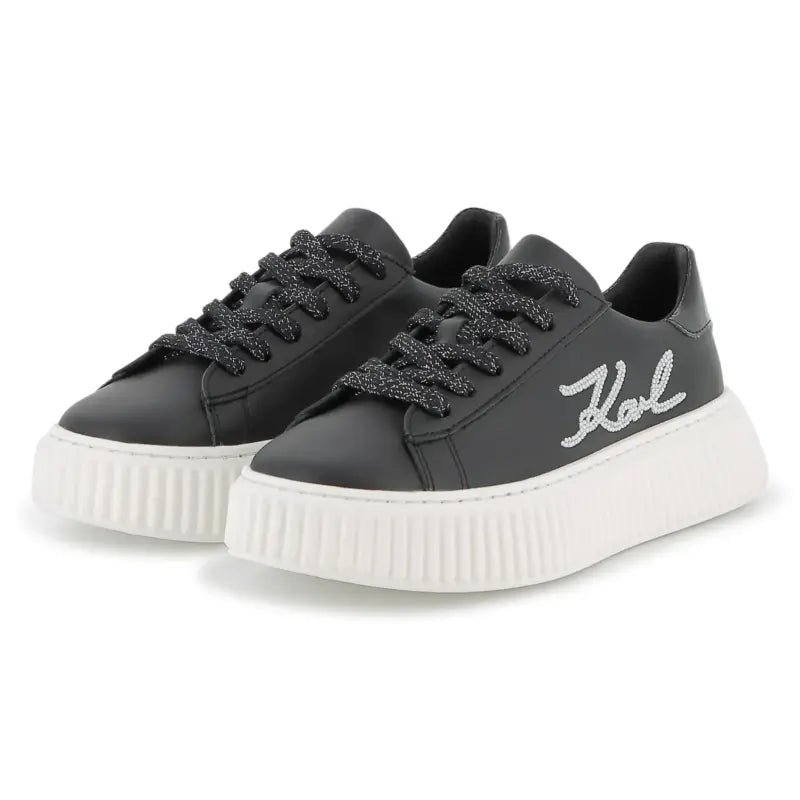 Black sneakers with white sole on a white background