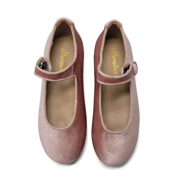 Pair of pink shoes with a strap on a white background