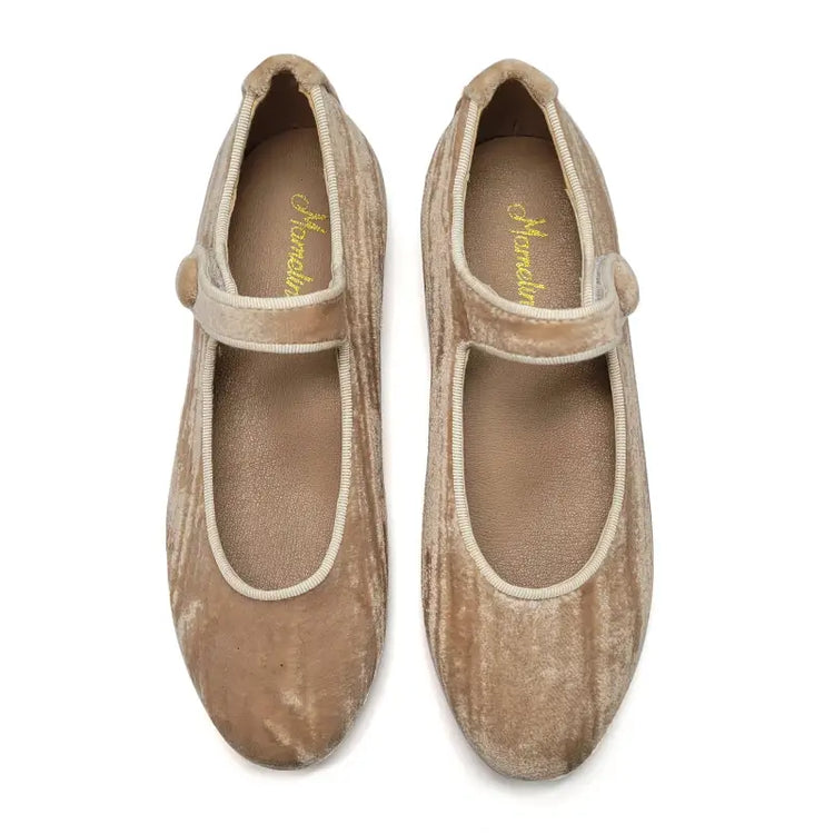 Pair of beige shoes with a strap on a white background