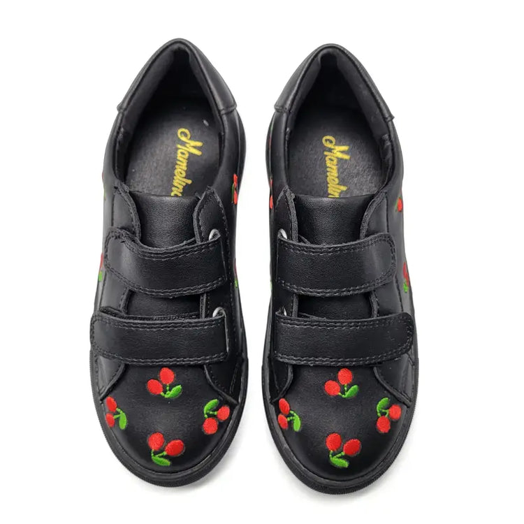 Black shoes with cherry designs on a white background