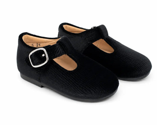 A pair of black Mary Jane style shoes with a textured fabric upper, a strap with a silver buckle, and a light tan interior, shown on a white background.