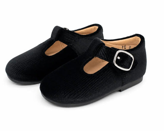 A pair of black Mary Jane style shoes with a textured fabric upper, a strap with a silver buckle, and a light tan interior, shown on a white background.