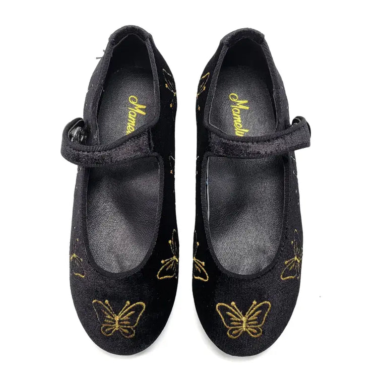 Black shoes with gold butterfly designs on a white background