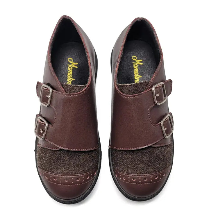 Pair of brown leather shoes with buckles on a white background