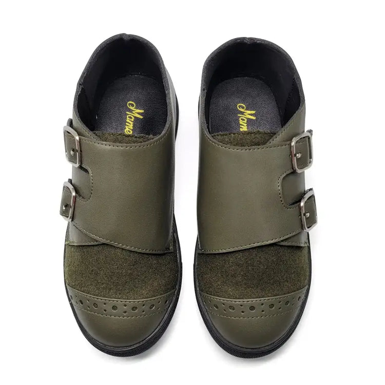 Pair of green shoes with buckles on a white background