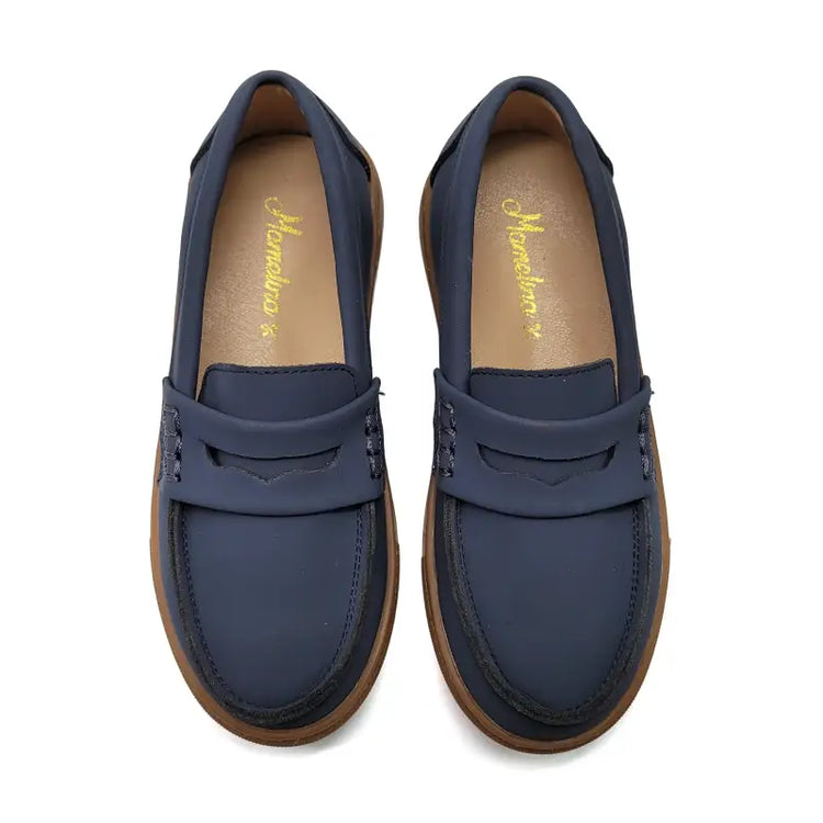 Pair of blue loafers with brown soles on a white background