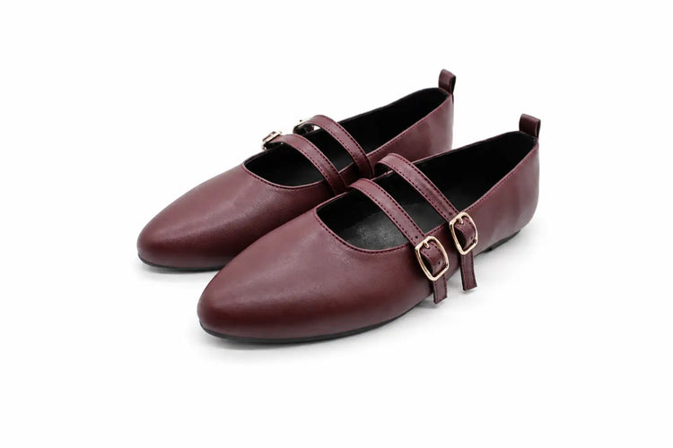 A pair of women's Mary Jane flats in burgundy leather with double straps and gold-tone buckle details, shown on a plain white background.