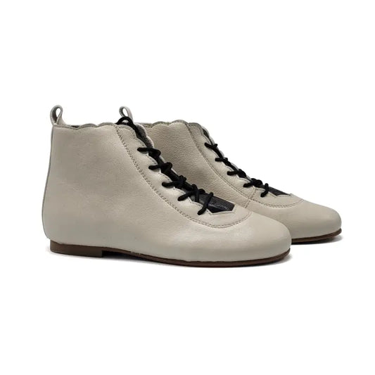 Pair of beige boot with black laces on a white background