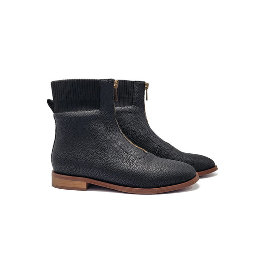 Pair of black ankle boots with brown soles on a white background