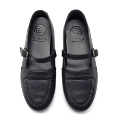 Black leather shoes with buckle details on a white background