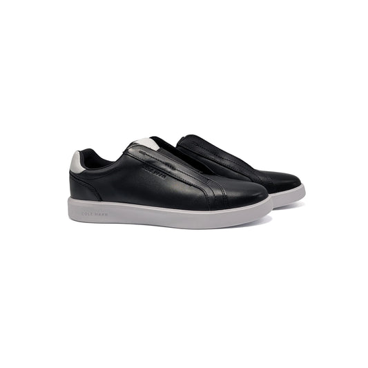 Black slip-on sneakers with white soles on a white background