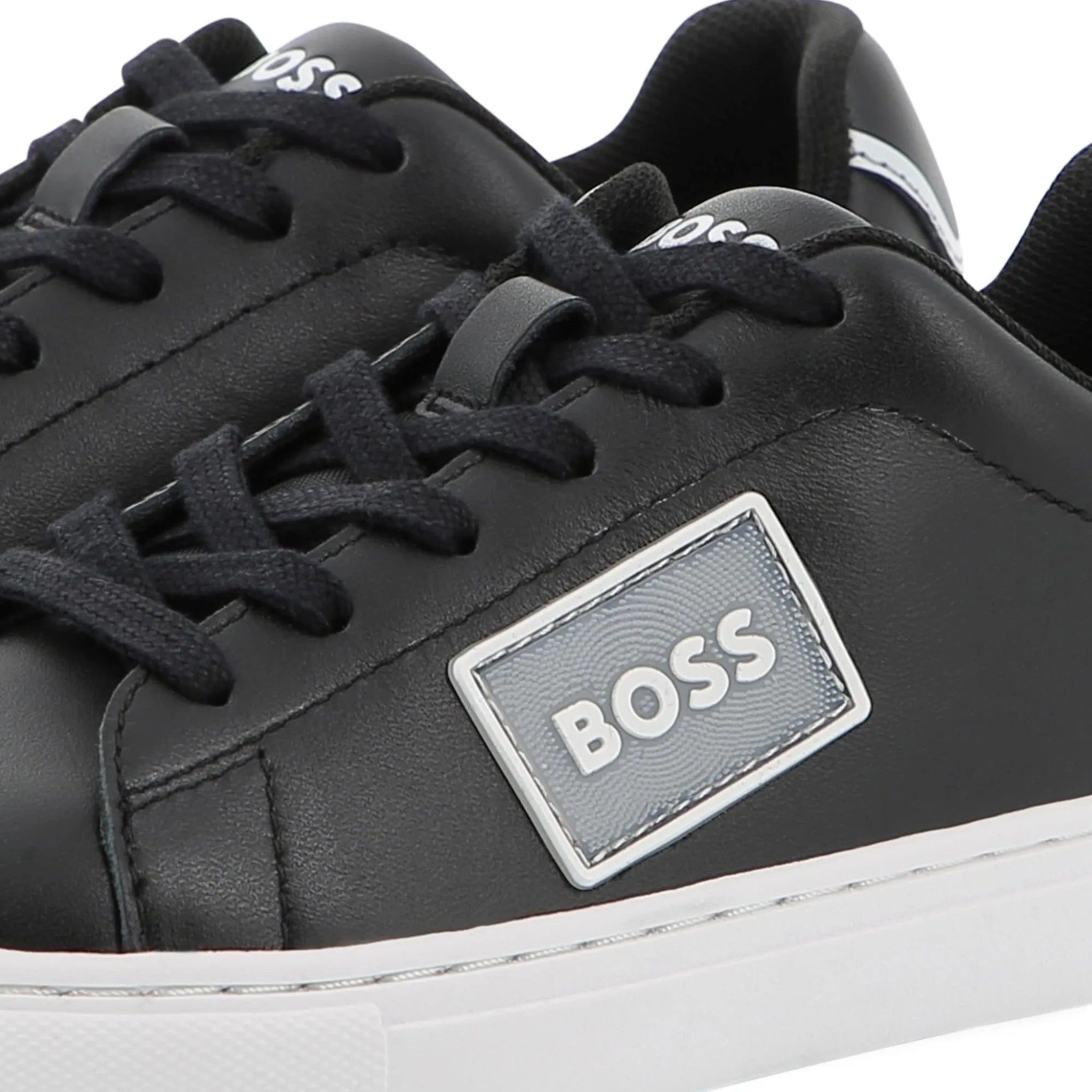 Black sneakers with a BOSS logo on a white background
