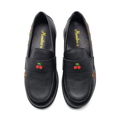 Black loafers with cherry designs on a white background
