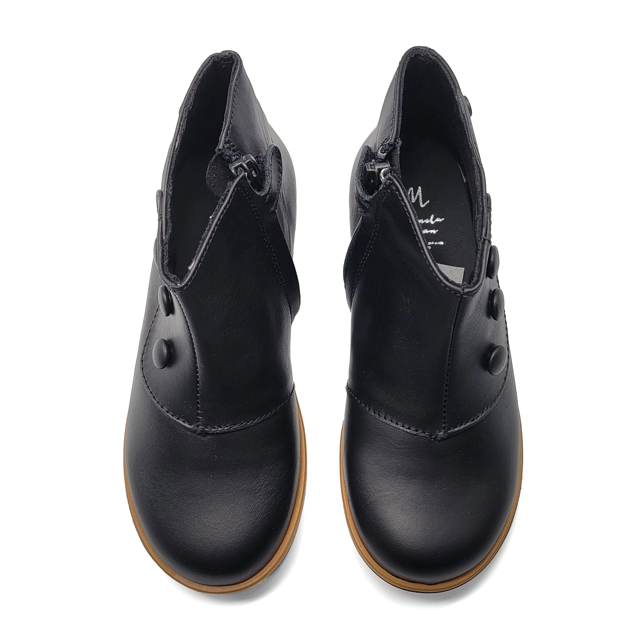 Pair of black leather shoes with brown soles on a white background