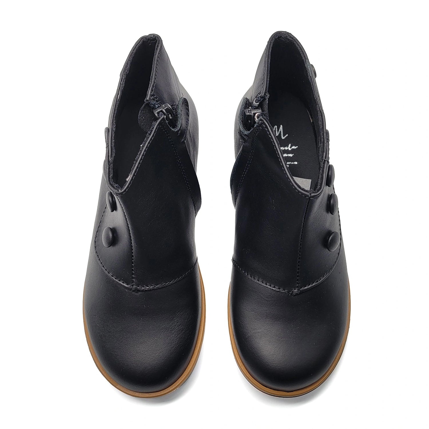 Pair of black leather shoes with brown soles on a white background
