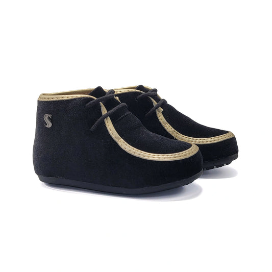 Pair of black shoes with beige accents on a white background