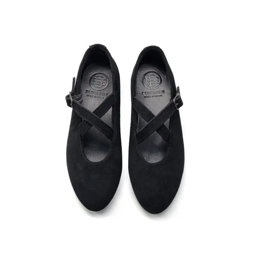 Pair of black mary jane with a criss-cross strap on a white background