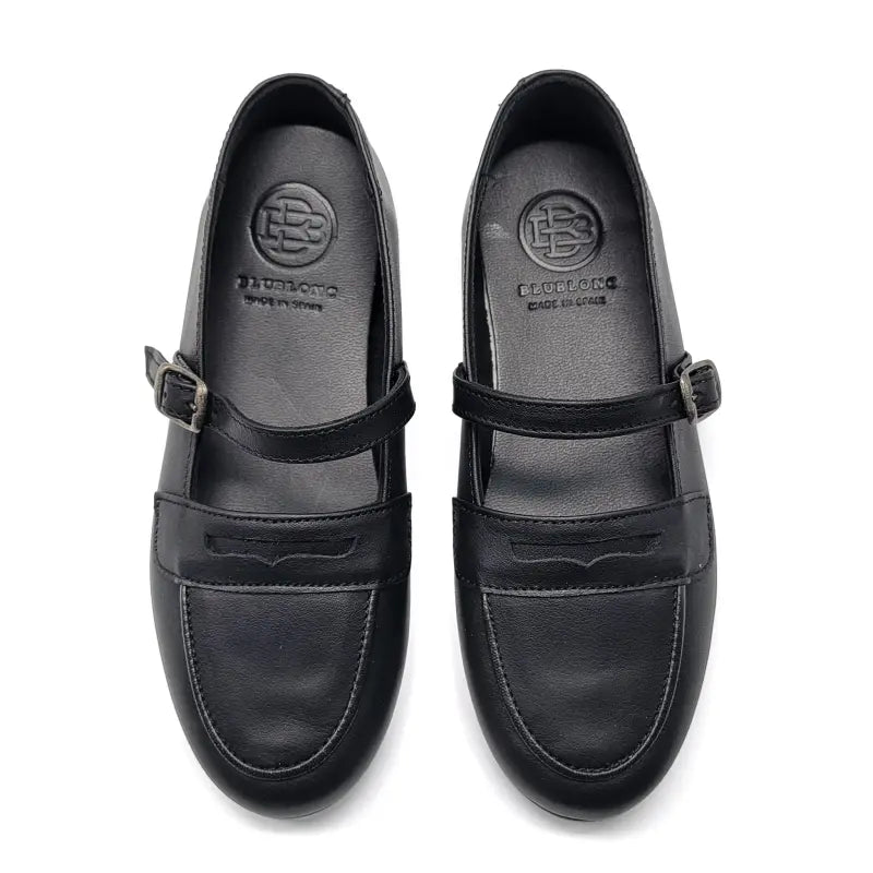 Black leather shoes with buckle details on a white background
