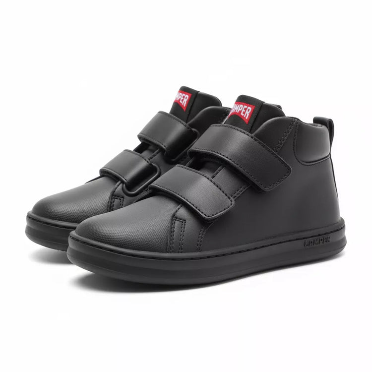 Black high-top sneakers with velcro straps on a white background
