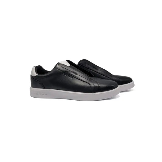 Black slip-on sneakers with white soles on a white background