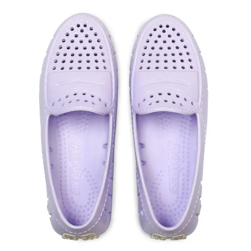 Pair of lavender shoes with holes on a white background