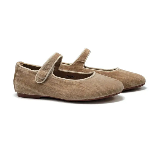 Pair of beige suede shoes with a strap on a white background