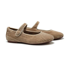 Pair of beige suede shoes with a strap on a white background