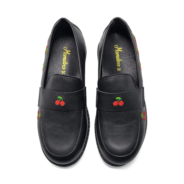 Black loafers with cherry designs on a white background