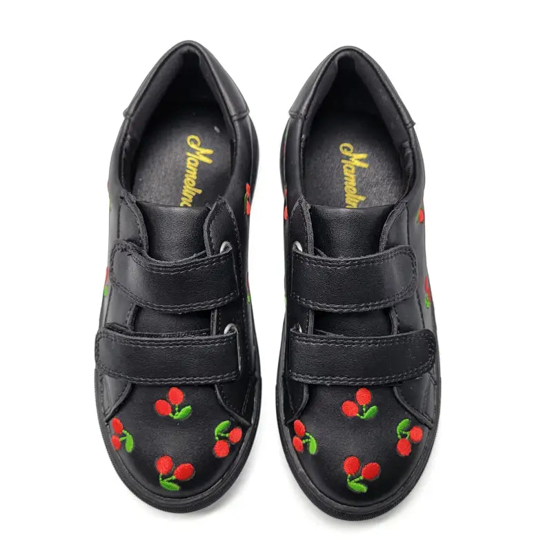 Black shoes with cherry designs on a white background