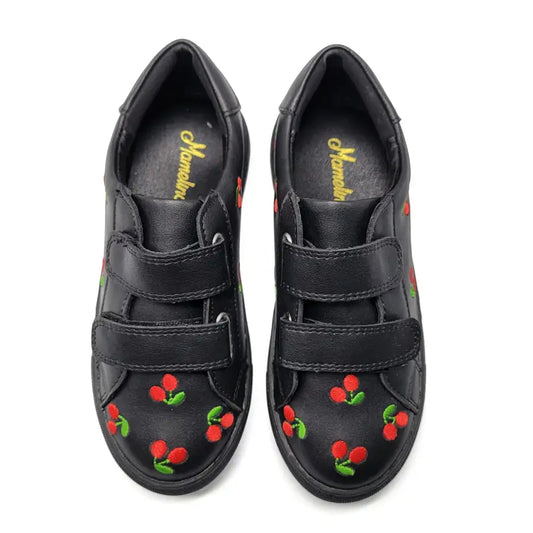 Black shoes with cherry designs on a white background