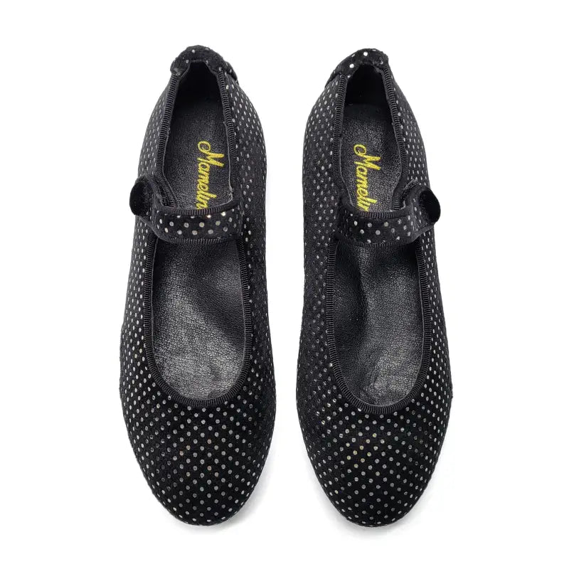 Pair of black polka dot shoes with a brand logo on a white background