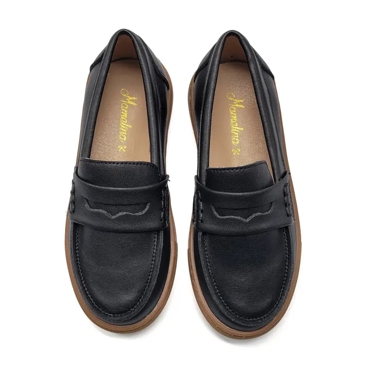 Black loafers with brown soles on a white background