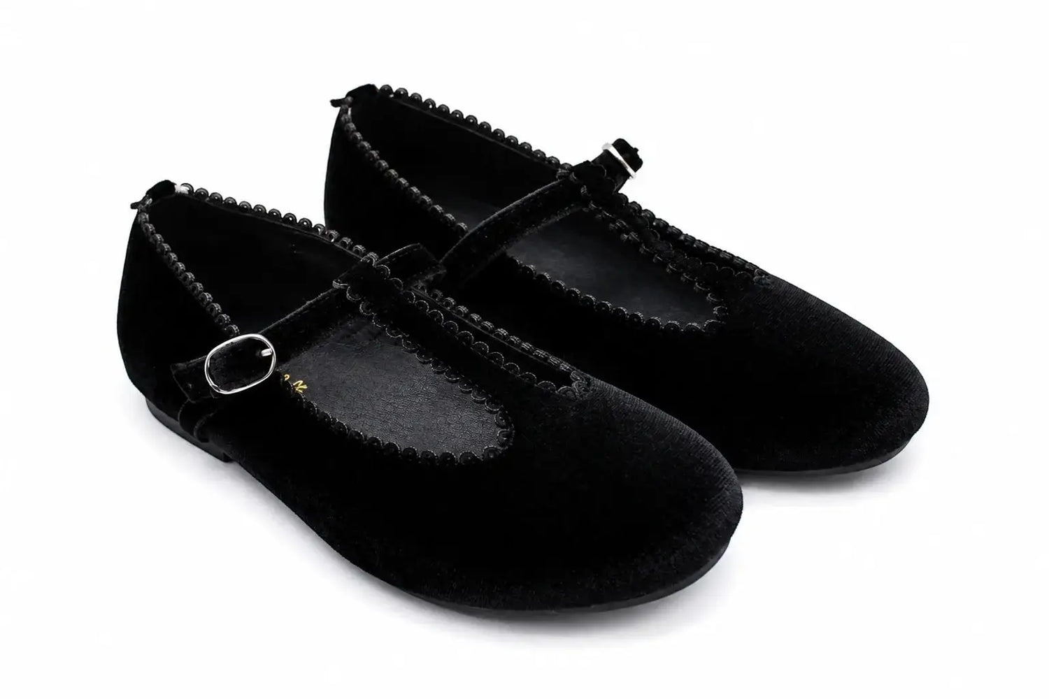 A pair of black velvet Mary Jane flats with braided trim and small silver buckle details, shown on a white background.