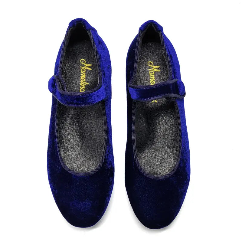 Pair of blue velvet shoes with a visible brand name on a white background