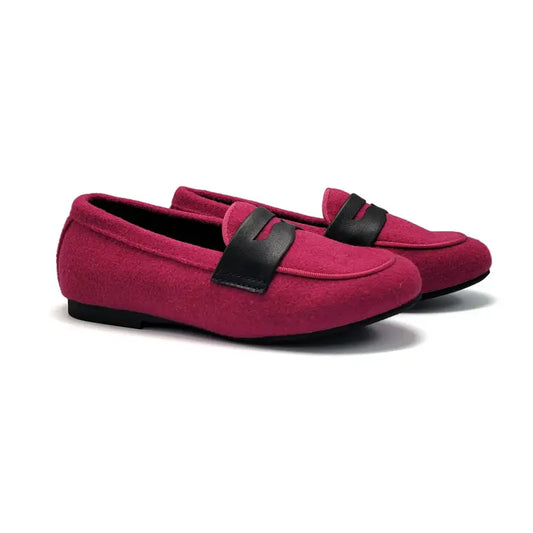 Pair of pink loafers with black straps on a white background