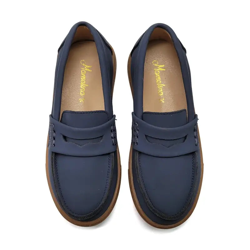 Pair of blue loafers with brown soles on a white background