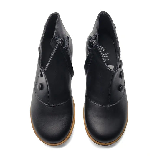 Pair of black leather shoes with brown soles on a white background