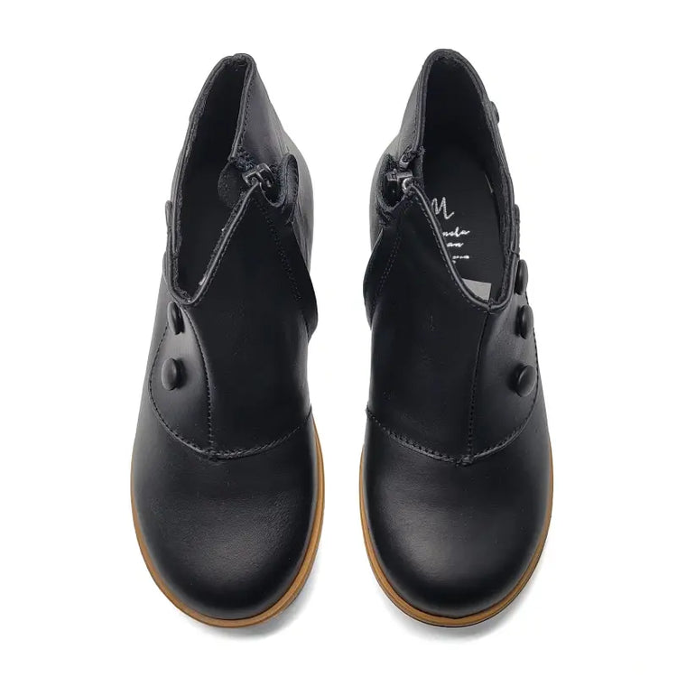 Pair of black leather shoes with brown soles on a white background