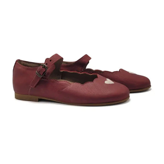Pair of maroon children's shoes with a heart design on a white background