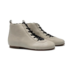 Pair of beige boot with black laces on a white background