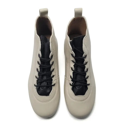 Pair of beige boot with black laces on a white background